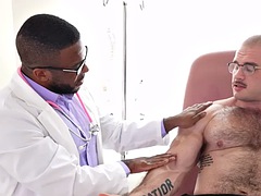 Muscular and oiled hunk masturbated by a black doctor in the infirmary