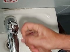 Felixproducer strokes his big cock in a public toilet, covering the sink and mirror with a massive load