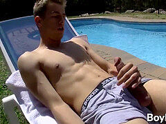 young gay man is all alone by the pool as he strokes off horny