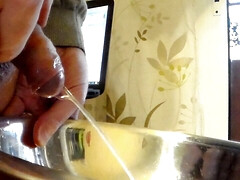 Closeup of John peeing into a steel bowl