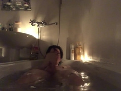 Young man takes a tub with candles and jizz there