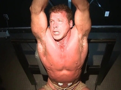 Moaning and trying not to show the pain in a BDSM setting