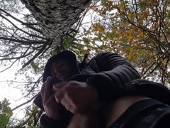 Bulky bodybuilder is milking off in woods outdoor public place