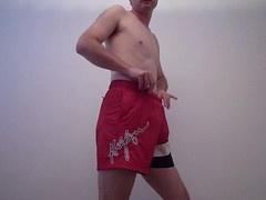 Handsome guy in red shorts playing with his hard cock and stroking
