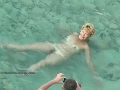 Many nude people are luving on the beach in the middle of a sunny day