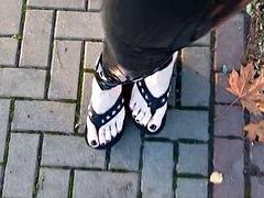 Crossdresser walks in public in latex tights and flip flops on a platform, showing off her sexy feet.