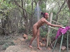 Naughty tattooed Indian babe takes a soapy shower in the forest of a nude resort