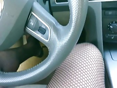 Horny crossdresser driving car in fishnet, dress and heels