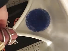 Chastity pissing in a public urinal
