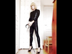 Crossdresser Faustine vinyl catsuit with necklace.