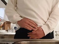 Desperate pee in a glass in the kitchen