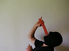 Hooded masked man deepthroat a plastic cock dildo