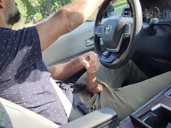 Driving hunk strokes his massive cock in the car