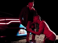 Bald man with tattoos is banged next to the vehicle