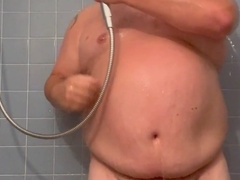 Witness the plump daddy shower, stroke, and ejaculate on his feet