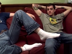 Tattooed twink gets a footjob before getting to blow cock