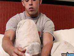 Young gay guy massages his feet and jerks off solo