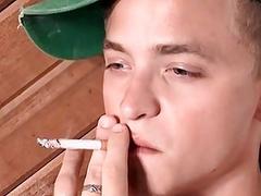 Dashing twink teases while smoking and stroking his dick solo