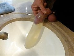Crossdresser pissing and filling a magnum Condom