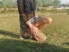 Crossdresser in multilayered nylons walking in a lake