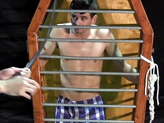 Caged boy is being whipped and seduced through BDSM