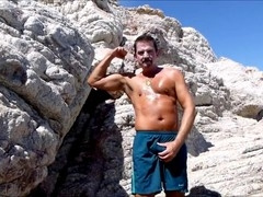 Guy in a Speedo gives a beachside jerk-off show and spills his load