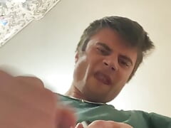 guy in a green T-shirt jerks off and cums on the phone
