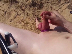 Bald twunk edging on a public beach