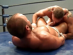 Muscular men fight in the ring in sexual perversions