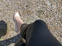 Crossdresser outdoor in shiny coated leggings and heels
