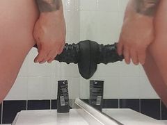 Carl cagedwarrior takes huge BBC dildo in hotel bathroom with mirror reflection