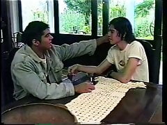 Hot stud sits on a table so his gay lover can suck his cock